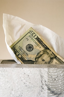 Twenty-dollar bill emerging from box of white tissues